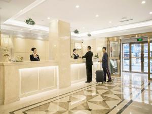 un gruppo di persone che si trovano nella hall di un hotel di Vienna Hotel Harbin Train Station Jianguo Street a Harbin