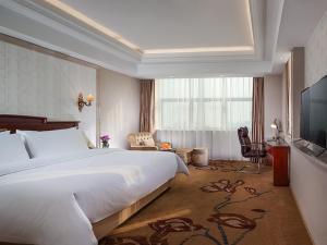 a hotel room with a large bed and a television at Vienna International Jiangsu Wuxi Taihu Expo Center in Wuxi