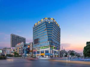 a tall building with lights on the top of it at 7Days Inn Danyang Train Station Wuyue Square Branch in Zhenjiang