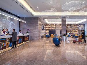 a lobby of a restaurant with people standing at a counter at Kyriad Marvelous Hotel Chengdu Wuhou Shuangnan in Chengdu