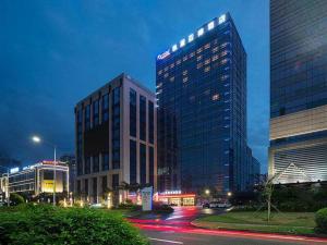 a tall building in a city at night at Kyriad Marvelous Hotel Zhongshan South District Conference Centre in Huancheng