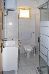 een badkamer met een toilet, een wastafel en een raam bij Appartamento Mare Marconi in Letojanni
