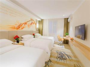 Llit o llits en una habitació de Vienna Classic Hotel Mudanjiang Railway Station