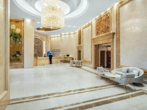 un hall avec des chaises et un lustre dans un bâtiment dans l'établissement Vienna International Hotel Taizhou Wenling Branch, à Taizhou