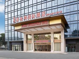 een gebouw met een bord aan de voorkant bij Vienna International Hotel South Gate of Shenzhen International Convention and Exhibition Center in Bao'an