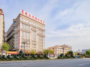 un gran edificio con un cartel en el lateral de una calle en Vienna International Hotel Fujian Quanzhou Jinjiang Airport en Jinjiang