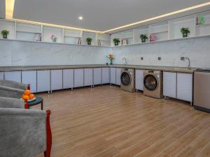 a living room with two washing machines in a room at Kyriad Marvelous Hotel Tai'an City Hall Plaza in Tai'an