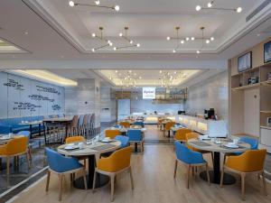 a restaurant with tables and chairs in a room at Kyriad Marvelous Hotel Guilin Quanzhou in Quanzhou +3 photos