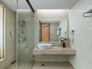 a bathroom with a sink and a shower at Vienna International Hotel Zhejiang Wenzhou Ruian Tangxia in Ruian