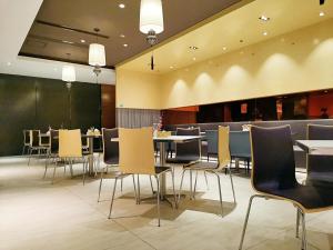 a dining room with chairs and tables in a restaurant at JinJiang Inn Zhenjiang Yangzhong Yangzi Road shop in Yangzhong