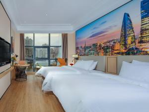 a hotel room with two beds and a large mural of a city at Vienna International Hotel Chongqing North Station in Chongqing