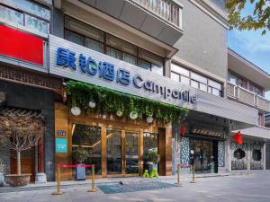 una tienda con un cartel en la parte delantera de un edificio en Campanile Yangzhou China Grand Canal & Ho Family Garden, en Yangzhou