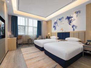 Letto o letti in una camera di Kyriad Hotel Baoying Jinyuan Square High-speed Railway Station