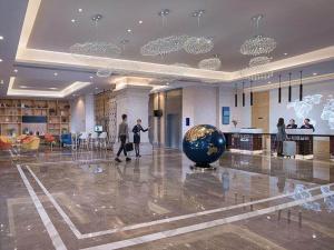 a lobby with a large ball in the middle of a building at Kyriad Marvelous Hotel Haikou Free Trade Zone in Haikou