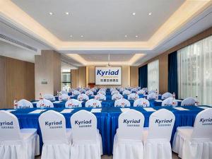 a room with tables and chairs in a room with kristhetical signs at Kyriad Hotel Luoyang Longmen Railway Station in Luoyang