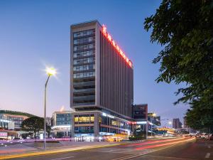 un edificio alto con luces encima en Vienna International Hotel Chongqing Yuanyangyuanboyuan en Chongqing