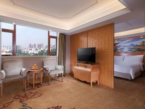a hotel room with a bed and a television at Vienna International Hotel Shenzhen Longhua Xikeng Subway Station in Tiantangwei