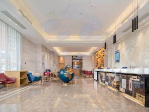 a lobby with a large ball in the middle of a building at Kyriad Marvelous Hotel Dongguan Municipal Government in Dongguan