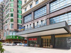 a large building with cars parked in front of it at Kyriad Marvelous Hotel Dongguan Changan Light Rail Station in Nongyucun