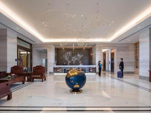 un vestíbulo con un jarrón en medio de un edificio en Kyriad Marvelous Hotel Dongguan Huangjiang Jingyi en Dongguan