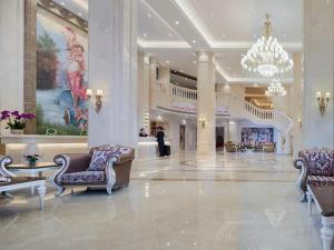 eine Lobby mit Stühlen und einem Kronleuchter in einem Gebäude in der Unterkunft Vienna International Hotel Ganzhou Longnan in Longnan