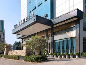 a building with a sign on top of it at Kyriad Marvelous Hotel Shenzhen Longhua Mission Hills Bamboo Village Subway Station in Bao'an