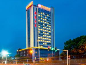 Un palazzo alto con un cartello sul lato. di Vienna Hotel Jiangsu Danyang Railway Station a Danyang