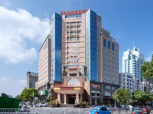un grand bâtiment dans une ville avec des voitures dans l'établissement Vienna International Hotel Taizhou Wenling Branch, à Taizhou