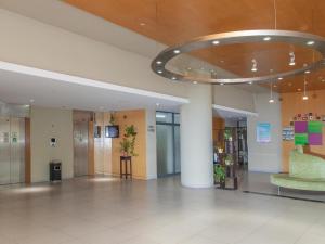 a lobby with a green chair in a building at Jinjiang Inn Zhenjiang Suzhou University Suning Plaza in Zhenjiang