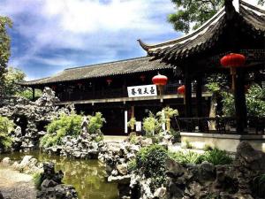 a building with a pond in front of a temple at Jinjiang Inn Select Yangzhou Slender West Lake Siwangting Road in Yangzhou