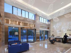 a large lobby with a blue couch in a building at Kyriad Marvelous Hotel Suzhou Wujiang People Square in Suzhou