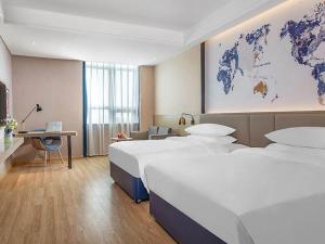 BoluoにあるKyriad Marvelous Hotel Huizhou Boluo Yuanzhouのベッド2台付きの客室で、壁に世界地図を用意しています。 +13枚の写真
