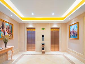 a large room with a yellow ceiling and paintings at Vienna Hotel Lukou Airport in Jurong