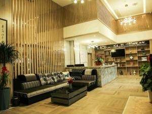 a living room with a couch and a bar at Magnolia Business Hotel Yangzhou Wanda Plaza Shunda Road in Yangzhou