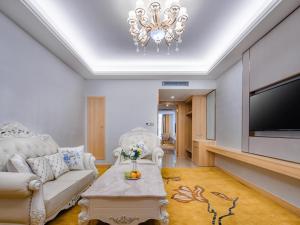 uma sala de estar com um sofá e uma televisão em Vienna International Hotel Fujian Quanzhou Jinjiang Airport em Jinjiang