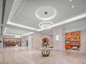 a lobby with a vase of flowers on a table at Vienna International Hotel Chongqing Central Park 5 0 in Chongqing