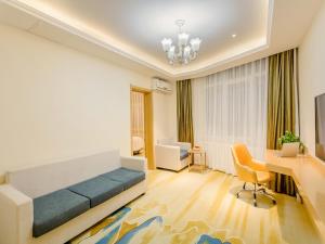 1 dormitorio con cama, escritorio y sofá cama en Vienna Classic Hotel Mudanjiang Railway Station en Mudanjiang