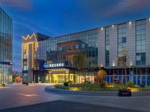 a large building with a lot of windows at Kyriad Marvelous Hotel Shanghai International Tourist Resort Pudong Airport in Nanhui