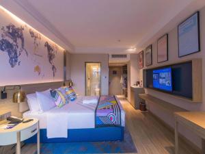 Cette chambre comprend un lit et une télévision à écran plat. dans l'établissement Kyriad Marvelous Hotel Shenzhen Linheng Plaza Liuyue Subway Station, à Liantang