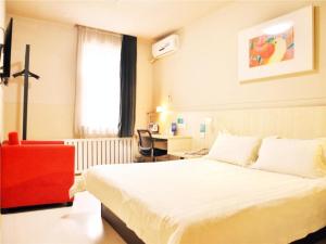 Habitación de hotel con cama y silla roja en Jinjiang Inn Changchun Railway Station New Branch, en Changchún