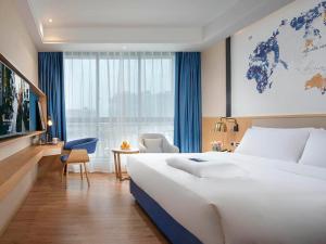 漢中的住宿－凯里亚德酒店(汉中高铁站店)，酒店客房设有一张白色大床和一个窗户。