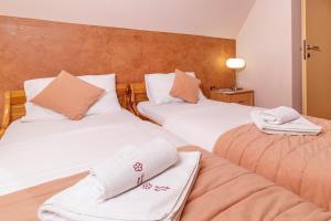 two beds with towels on them in a room at Kraljevi Konaci - Najam kuća na Zlatiboru in Zlatibor