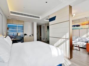 a bedroom with a large white bed and a desk at Kyriad Marvelous Hotel NanChang Xiang Lake Jinsha Avenue in Nanchang +36 photos