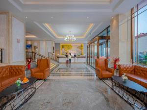 a lobby of a hotel with couches and windows at Vienna Hotels Yuncheng Hedong Street Wanda Store in Yuncheng