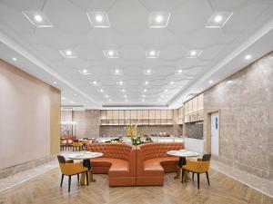 a lobby with a couch and tables and chairs at Vienna International Hotel Chongqing Central Park 5 0 in Chongqing