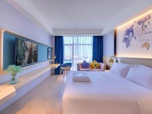 ein Schlafzimmer mit einem großen weißen Bett in einem Zimmer in der Unterkunft Kyriad Hotel Pingxiang Wanlong Bay Branch in Pingxiang