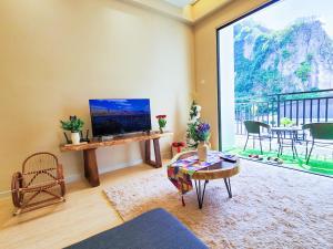 イポーにあるThe COVE at Ipoh Garden East 7 PAX Cozy Fully Air-Conのテレビと大きな窓のあるリビングルーム