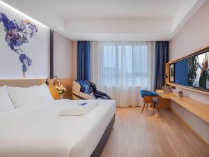Pokój hotelowy z dużym łóżkiem i telewizorem w obiekcie Kyriad Marvelous Hotel Jingxian w mieście Jing
