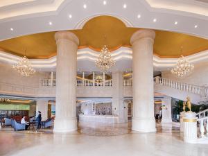 eine Lobby mit Säulen und Kronleuchtern in einem Gebäude in der Unterkunft Vienna International Hotel ASEAN Avenue Dongxing in Fangchenggang