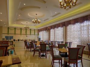 una sala da pranzo con tavoli e sedie in un ristorante di Vienna Hotel Jiangsu Danyang Railway Station a Danyang